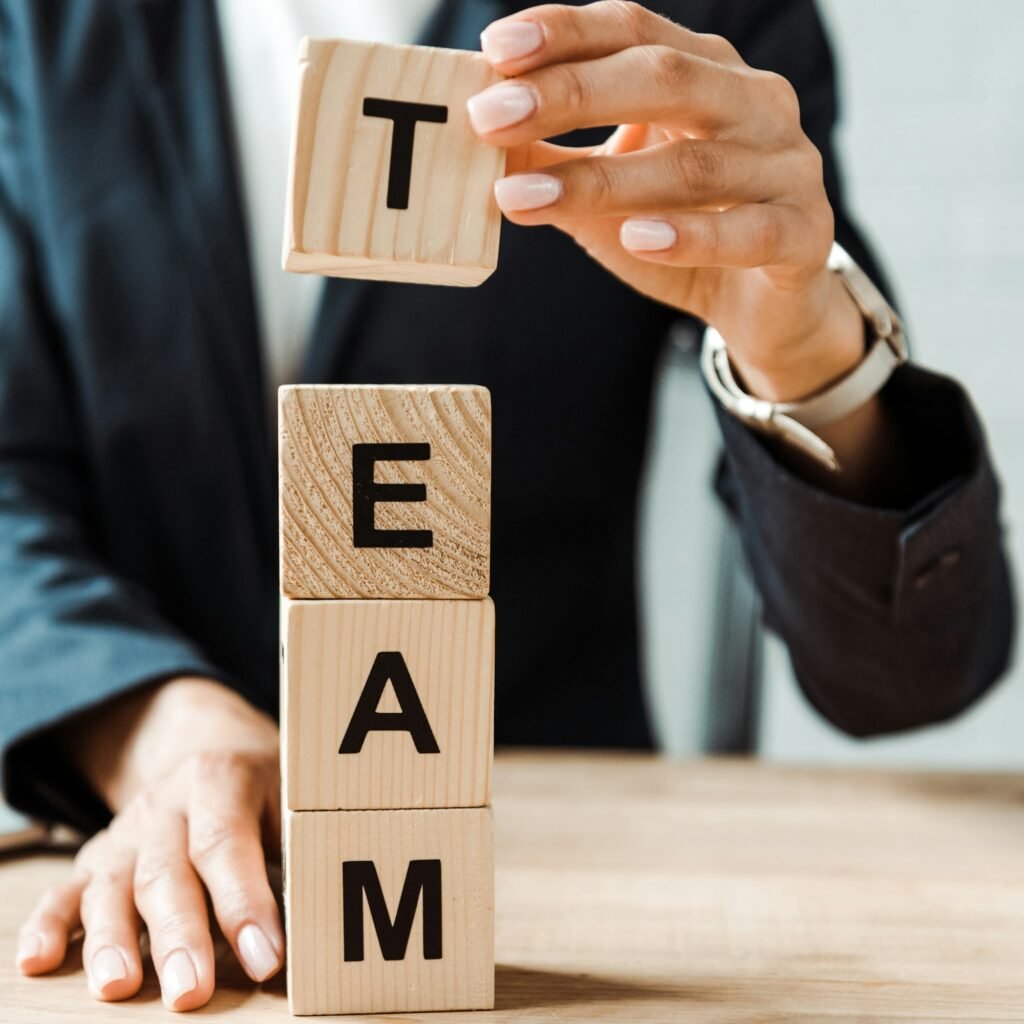 cropped view of businesswoman touching wooden cubes with team letters